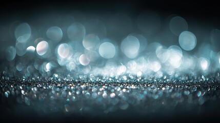 Soft silver bokeh lights with glittering particles in a moody dark background