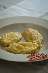 Homemade traditional Sardinian pasta called Culurgiones on a porcelain plate