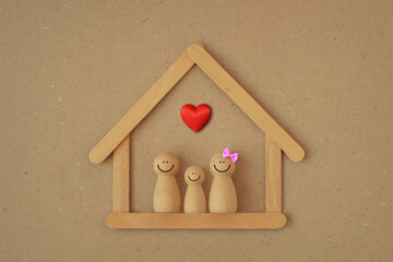 Wooden pawn family in a house made of wooden sticks with heart - Love and family union concept