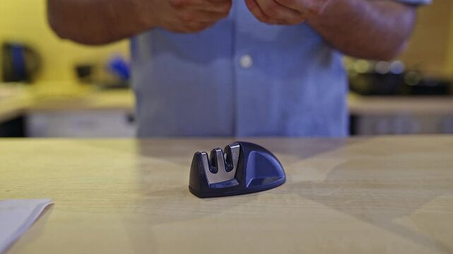 Witness a man restoring the sharpness of a kitchen knife using a compact sharpener. The video features a clear demonstration of the blade's improved cutting ability on paper, complete with sounds.