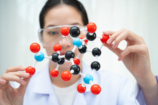 Scientist holding molecular model for chemical technology.