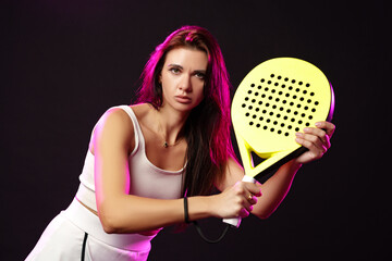 Young athlete preparing for a match with paddle racket in a studio setting