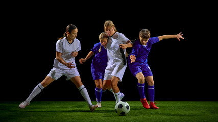 Teenage girls soccer players fighting for ball in multi-player action cluster. Concept of youth tactical training, pressure situations education, teamwork development tools.