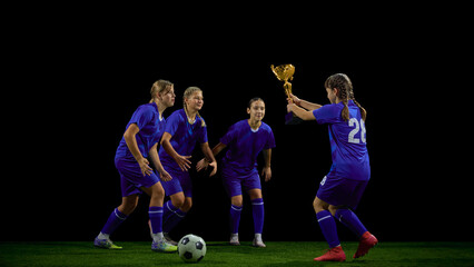 Teenage soccer player presenting trophy to teammates during post-match moment. Concept of youth sports ceremonies, award interaction, team culture, achievement promotion.