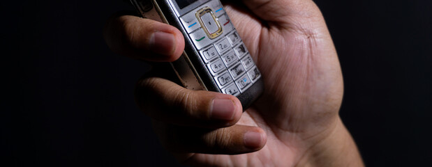 Extreme close-up of worn numeric keys on an old mobile phone held in a hand, emphasizing tactile buttons and device wear. Great for themes of analog input and aging gadgets.