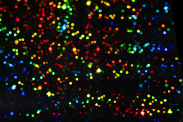 Black background with colorful bokeh lights, vibrant, festive, and atmospheric mood. Defocused multicolored glowing circles backdrop for design.