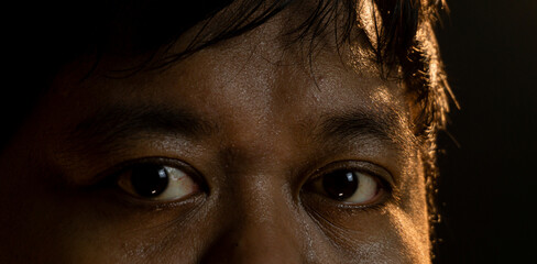 Tight close-up of a man?s eyes looking forward, captured in cinematic warm lighting that emphasizes skin texture and reflective highlights. Suitable for emotion, awareness, and observation