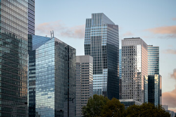 Architecture and skyscraper façades in Paris where reflection surfaces highlight finance and business ideas throughout the urban landscape belonging to the corporate district of La Defense.