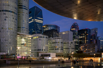 Architecture and skyscraper volumes emerging in Paris where evening reflection accentuates finance and business themes across the urban landscape linked to the corporate district of La Defense.