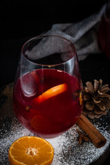 Mulled wine with citrus and spices in rustic winter setting