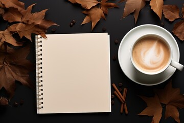 A white coffee cup sits on a table with a spiral notebook
