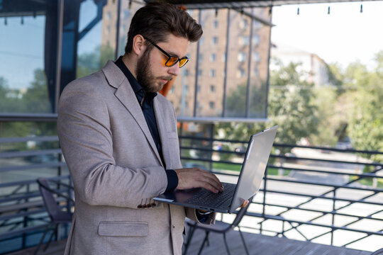 A man is working on his laptop outdoors