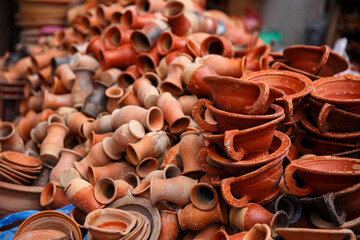 Clay pottery stacked at a traditional market.