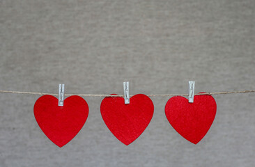 Three images of hearts are suspended on a thin rope