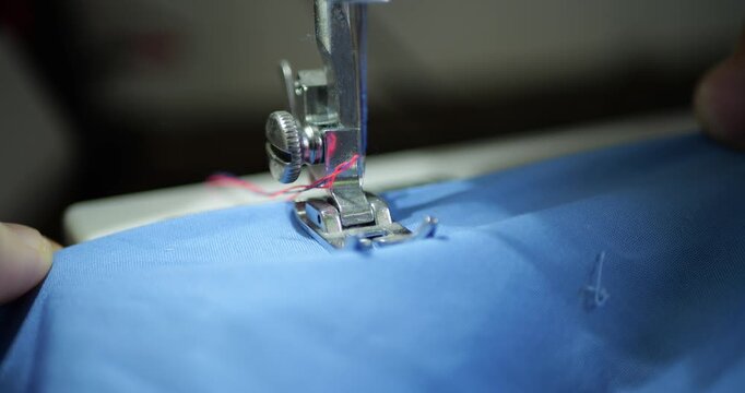 Sewing Machine Close Up Stitching Blue T-shirt. Textile Manufacturing, Mass Production Process. Fashion Business, E-commerce, Marketplace Product, Industrial Work, Fast Fashion Industry