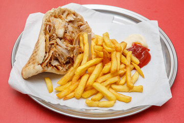 Sandwich d&ouml;ner kebab avec frites et sauces dans un plateau, restauration rapide. Fond rouge