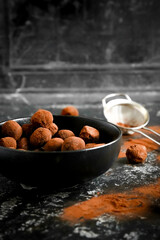 Homemade chocolate and gingerbread truffles coated in cocoa powder, arranged on a baking tray and served in a rustic dark setting. Ideal for festive, winter or Christmas-themed food and recipe content