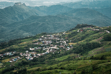 Fototapeta premium Beautiful mountain landscape with sea of mist, winding road, and resorts at Phu Thap Boek, Thailand.