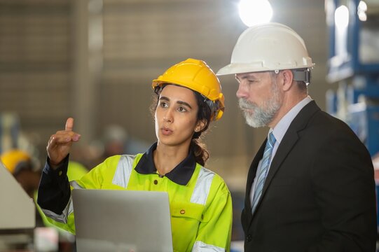 senior engineer manager boss bearded on face in white helmet and worker foreman survey check maintenance heavy machine construction factory after operation process metal sheet