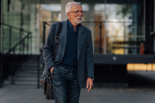 Senior man walking purposefully wearing business casual attire