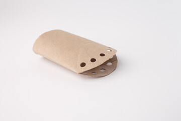 Repurposed toilet paper roll with curved edge and punched circles, useful for sustainability brands, eco packaging, craft stores, educational platforms, DIY marketing visuals.