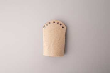 Recycled cardboard craft with punched holes, ideal for eco-friendly education, DIY tutorials, sustainability blogs, preschool activities, creative reuse campaigns, packaging or craft material branding