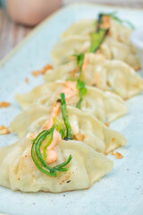 A vertical shot of gyoza drizzled with sauce