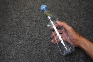 Hand Holding Used Crushed Plastic Bottle for Recycling