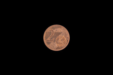 Old used and worn out 2 cents coin. Coin of European currency euro isolated on black background.