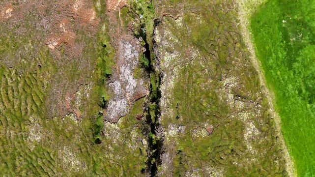 Aerial view of the northern Nor&eth;urland continental rift, showcasing rugged geology, plate cracks, and vast open terrain under bright light.