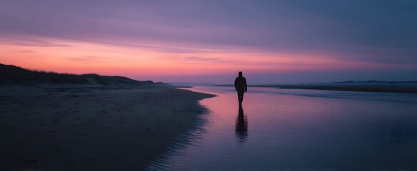 The solitary figure walks the sandy beach shoreline at dusk feeling deep quiet solitude