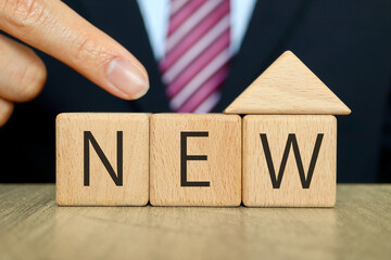 家の形のブロックとスーツの男性。NEW。新築や新生活のイメージ。