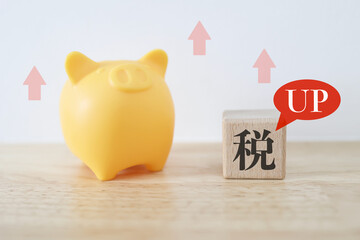 増税で家計負担が上昇するイメージ。貯金箱と税のブロック。