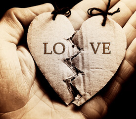 Broken paper heart on a hand. Black and white style