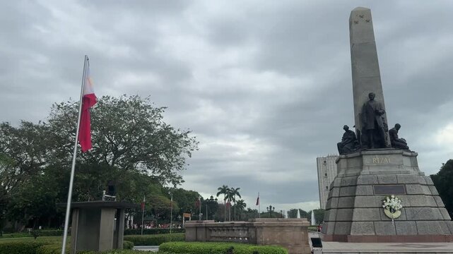March 2025, Manila, Philippines: Jose Rizal Luneta Park, A solemn stone monument stands under a cloudy sky