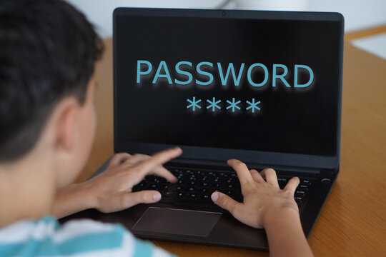 Cybersecurity for young people and children. Preteen boy typing a password on his laptop screen.