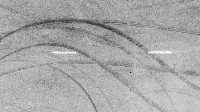 Aerial view abstract asphalt street road background with black tire marks on race track, Texture and background car automobile and automotive skid tire marks.
