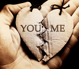 Broken paper heart on a hand. Black and white style