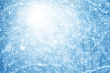 Snowy winter background in the park, blurred abstract seasonal backdrop, snowflake texture, light landscape background