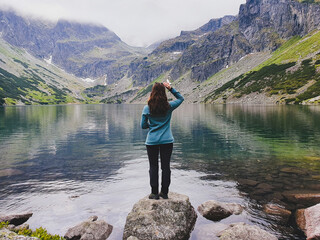 Beautiful brunette girl among fantastic mountain lake Morskie Oko