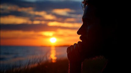 A man in deep thought gazing into the horizon at sunset