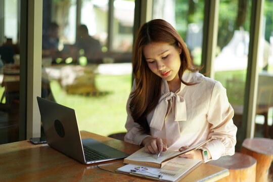 Woman working at a laptop in a cafe.