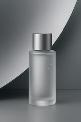 Frosted glass cosmetic toner bottle with satin silver cap standing against curved metallic grey backdrop, cool minimalist skincare packaging.
