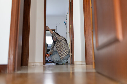 Woman accurately measuring door frame for home improvement project - Powered by Adobe