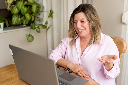 Senior woman attending video call, remote communication online, working from home with modern technology