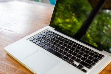 Outdoor Laptop On Wooden Table With Greenery Reflection For Modern Tech And Work In Bright Day