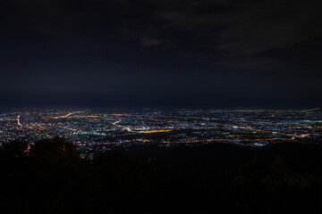 Chiang Mai city lights at night from the mountains above the vast cityscape.