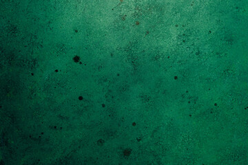 Green concrete wall with weathered texture and dark stains