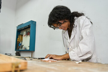 Woman creating handcrafted jewelry in workshop focusing on small details