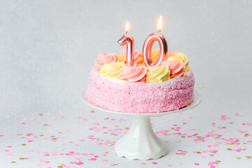 Fototapeta premium Celebrating a tenth birthday with a pink cake and candles on a festive table